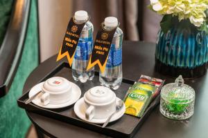 a table with a tray with two bottles of water and cups at HALO HANOI HOTEL in Hanoi