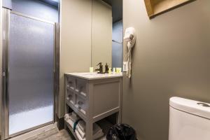 a bathroom with a sink and a shower at La Suite Hotel in Shawinigan