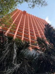 a tall orange building with palm trees in front of it at The Reforma 27 Grand in Mexico City +84 photos