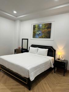 a bedroom with a bed and a painting on the wall at khách sạn yên châu 2 in Chau Doc