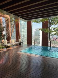 a swimming pool on a deck with a view of a city at The Reforma 27 Grand in Mexico City