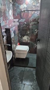 a bathroom with a toilet and a stone wall at D3 Homes in Jāmb