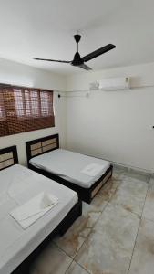 two beds in a room with a ceiling fan at D3 Homes in Jāmb