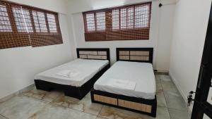 two beds in a room with two windows at D3 Homes in Jāmb