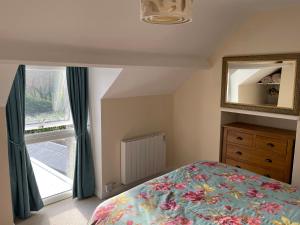 a bedroom with a bed and a mirror and a window at Willow Nook in Whitby