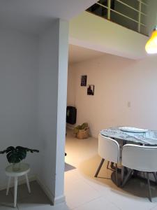 a dining room with a table and white chairs at Departamento morderno y centrico-Paseo Plaza in Navarro