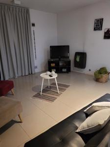 a living room with a table and a tv at Departamento morderno y centrico-Paseo Plaza in Navarro