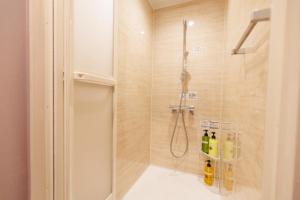 a bathroom with a shower with bottles on the floor at Morethan Paradise in Nagatoro +14 photos