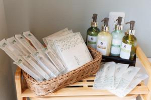 a basket with books and wine bottles on a shelf at Morethan Paradise in Nagatoro