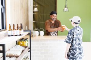 a man is giving a child a drink at Morethan Paradise in Nagatoro