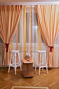 a room with two stools and curtains at Apartament Ema Baile Felix in Baile Felix