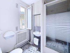 a bathroom with a sink and a toilet and a window at HOTEL WATTIGNIES in Paris +24 photos