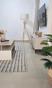 a living room with a table and a rug at Nala Host - 2BR Garden Home in Hulhumale