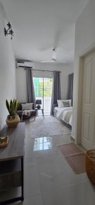 a bedroom with a bed and a living room at Nala Host - 2BR Garden Home in Hulhumale