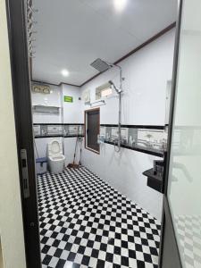 a bathroom with a toilet and a checkered floor at Ninh Binh Friendly Hotel in Ninh Binh