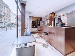 a restaurant with a counter and chairs in a street at HOTEL WATTIGNIES in Paris