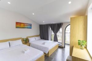 a hotel room with two beds and a window at Tidal Mist Homestay in Long Hai