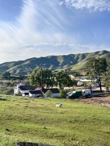 a field with a farm and mountains in the background at Zaromelranch deck in Agua Dulce