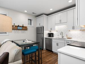a kitchen with white cabinets and a table and a couch at Cozy Capri Condo: Charming 1BR 1BA Downtown! in Traverse City