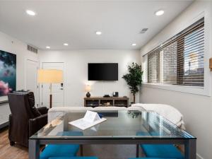a living room with a glass table and a tv at Cozy Capri Condo: Charming 1BR 1BA Downtown! in Traverse City
