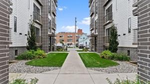 a walkway between two brick buildings with grass at Cozy Capri Condo: Charming 1BR 1BA Downtown! in Traverse City