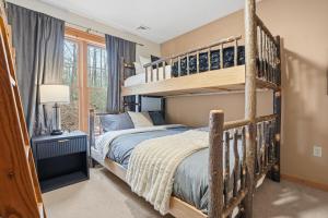 a bedroom with a bunk bed with a ladder at Luxury Poconos Chalet - 3 Mins to Camelback in Tannersville