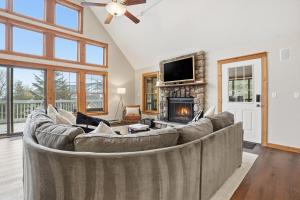 a living room with a large couch and a fireplace at Luxury Poconos Chalet - 3 Mins to Camelback in Tannersville
