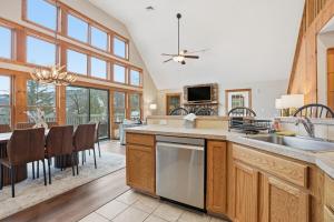 a kitchen with a sink and a table with chairs at Luxury Poconos Chalet - 3 Mins to Camelback in Tannersville