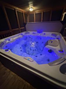 a jacuzzi tub with blue lighting in a room at Luxury Poconos Chalet - 3 Mins to Camelback in Tannersville +28 photos