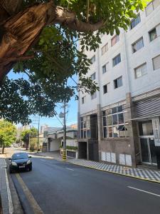 a car driving down a street next to a building at Apartamento no centro com ar-condicionado in Piracicaba