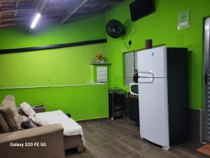 a kitchen with green walls and a refrigerator at Pousada do Sossego Mar e verde 3 in Itanhaém