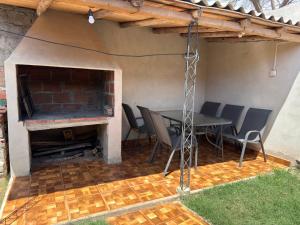 a patio with a table and chairs and a fireplace at CASA Costanera in Cafayate