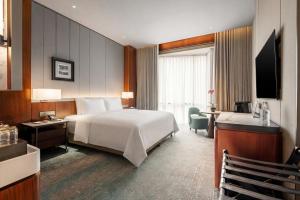 a hotel room with a large bed and a desk at St Giles Mid Valley Kuala Lumpur in Kuala Lumpur