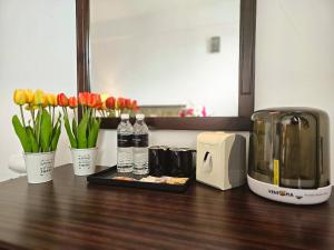 a counter with flowers and bottles of water and a toaster at Swing & Pillows - Bandar Kuantan in Kuantan