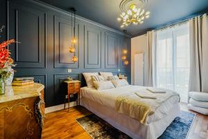 a bedroom with a large bed and a chandelier at Maison Saint Lazare in Vernon