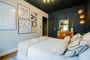 a bedroom with a large white bed with pillows at Maison Saint Lazare in Vernon