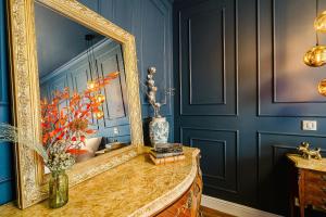 a mirror sitting on a table in a room with blue walls at Maison Saint Lazare in Vernon