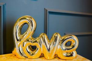 a gold object shaped like the word love sitting on a table at Maison Saint Lazare in Vernon +27 photos