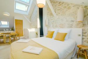 a bedroom with a large white bed with yellow pillows at Maison Soleil Levant in Vernon