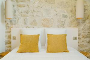 a bedroom with a white bed with two yellow pillows at Maison Soleil Levant in Vernon