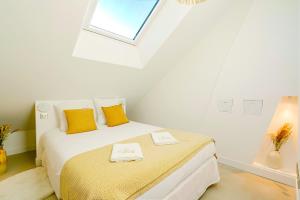 a bedroom with a bed with yellow pillows and a window at Maison Soleil Levant in Vernon