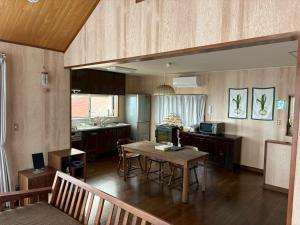 a living room with a table and a kitchen at Atami Ocean & Star Cottage in Atami