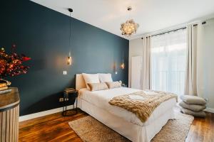 a bedroom with a large bed and a blue wall at Maison Kolsaas in Vernon