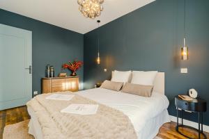 a bedroom with a large white bed with blue walls at Maison Kolsaas in Vernon +23 photos