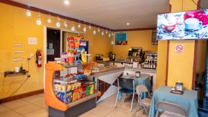 a restaurant with yellow walls and a counter with chairs at Hotel HASA in Managua