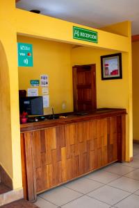 a hotel reception desk in a yellow room at Hotel HASA in Managua