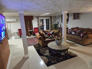 a living room with couches and a tv at Cozy Mobay in Hampton