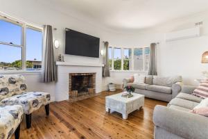 a living room with a fireplace and a tv at Selah - 36 Woodburn Street in Evans Head