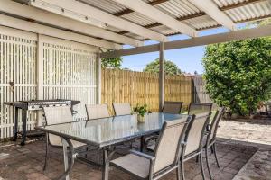a patio with a table and chairs and a piano at Selah - 36 Woodburn Street in Evans Head