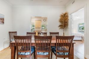 a dining room with a wooden table and chairs at Selah - 36 Woodburn Street in Evans Head +11 photos